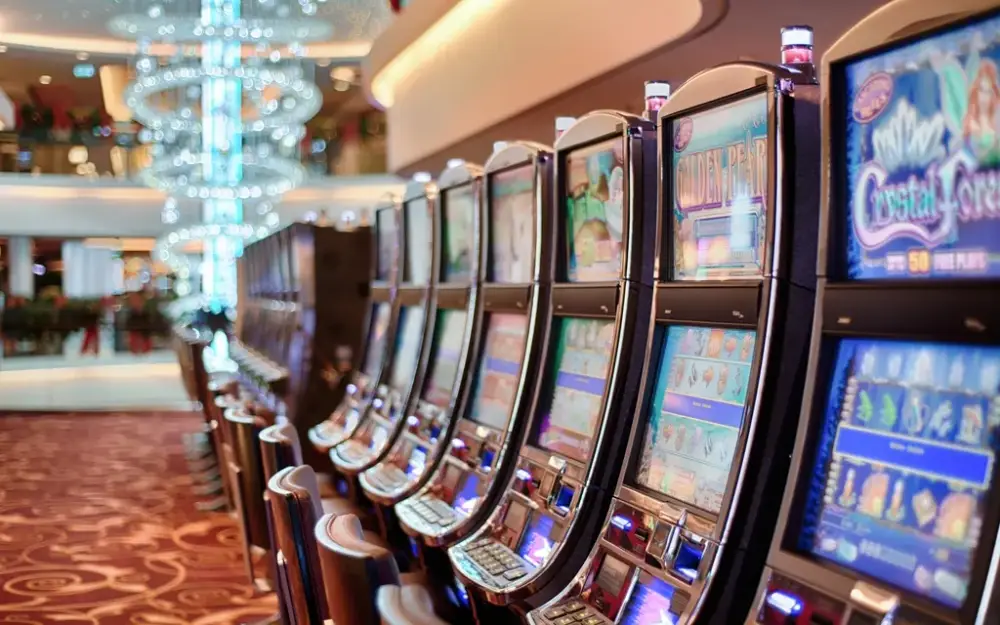 Row of brightly lit slot machines on a casino floor